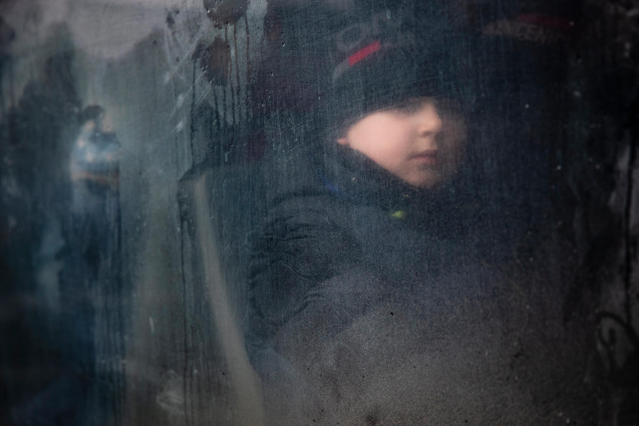 Lapsi katsoo ikkunasta Ukrainassa EPA