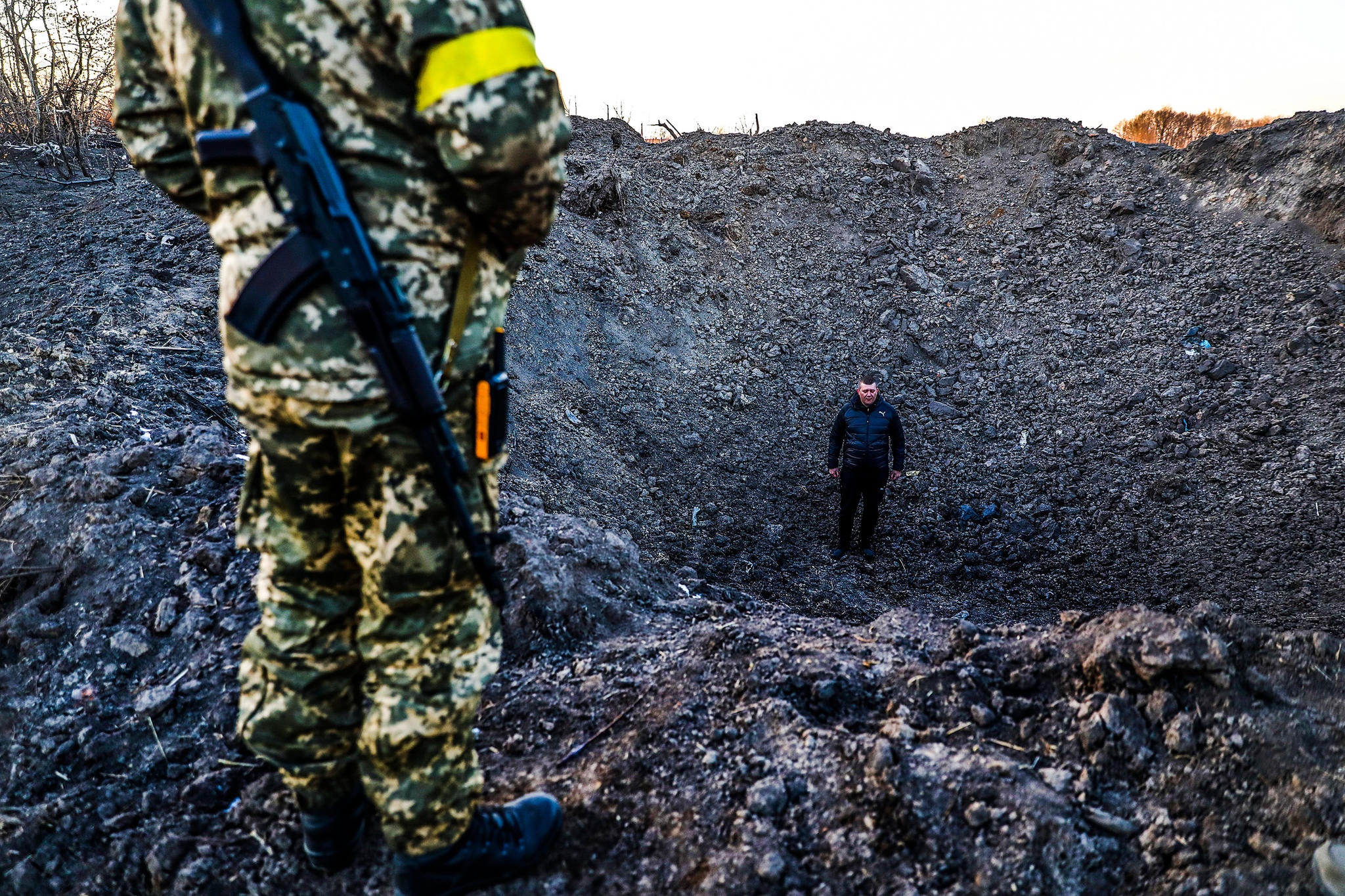 Ihmisiä räjähdyskuopassa Ukrainan sodan aikana.