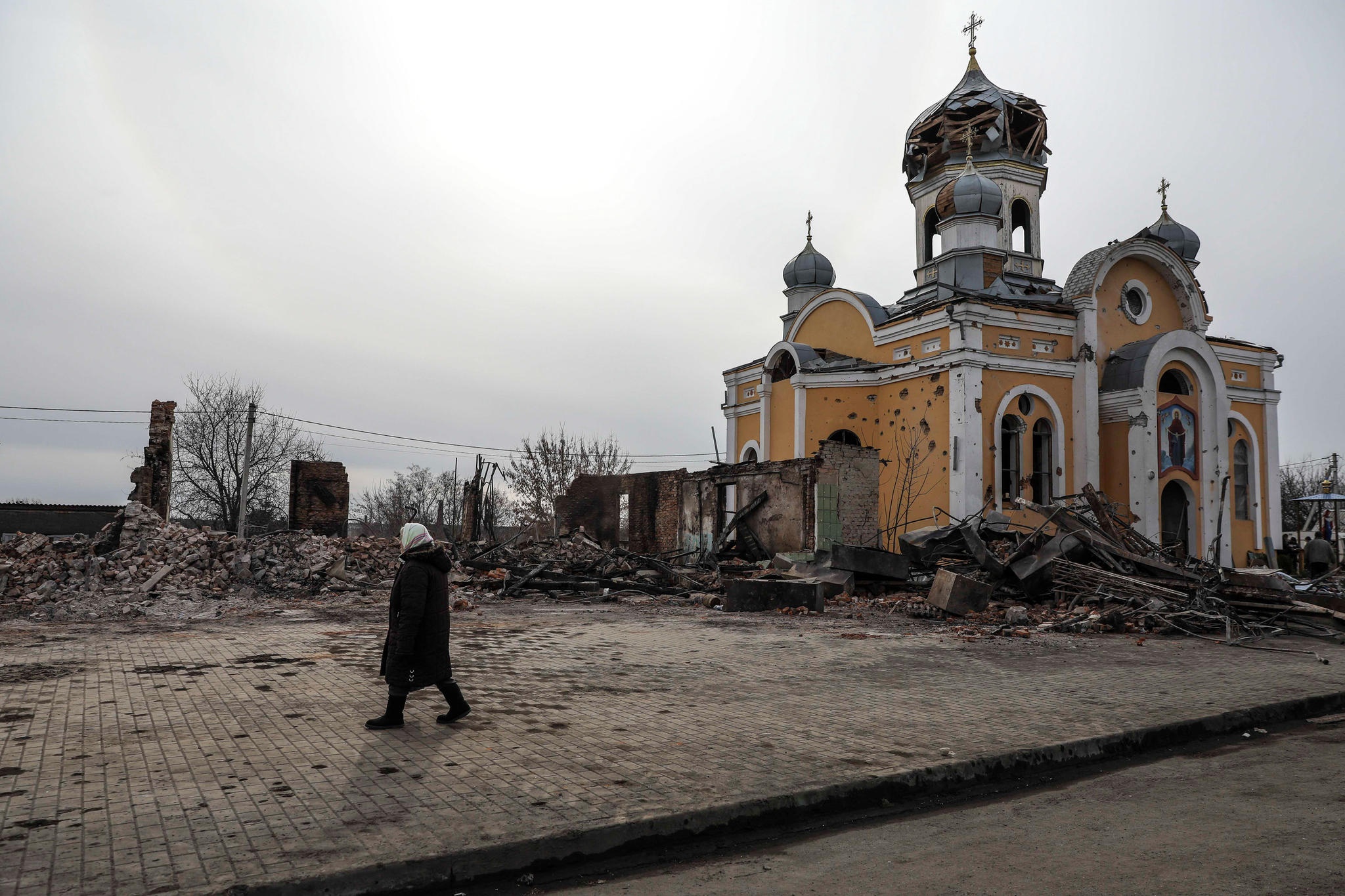 Ihminen kirkon edessä Ukrainan sodan aikaan.