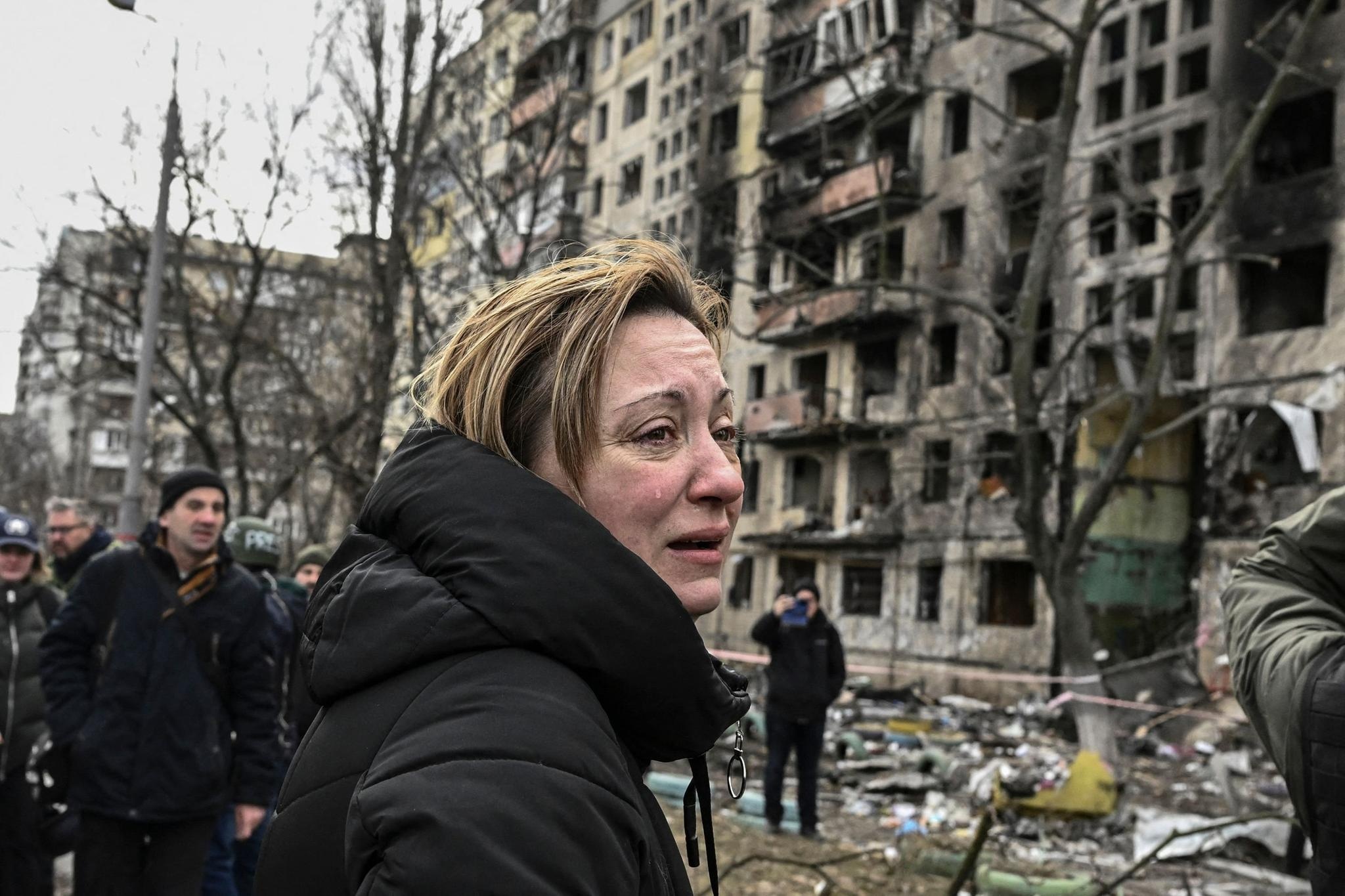 Nainen itkee kerrostalon edessä Kiovassa 14. päivä maaliskuuta.