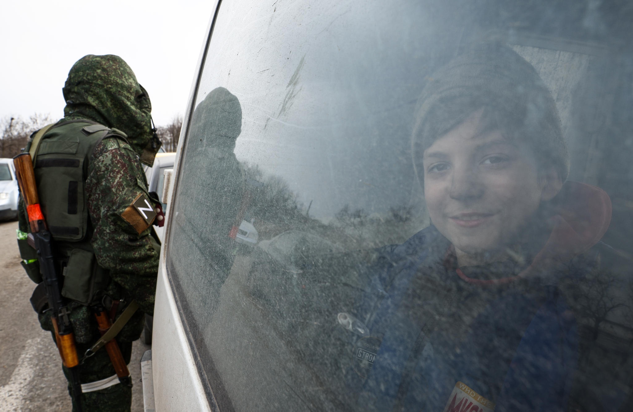 Lapsi katsoo ikkunasta Mariupolin humanitaarisessa käytävässä.