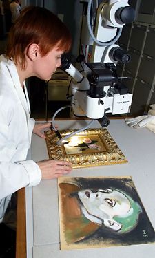 Paperikonservaattori Nora Haikala tutkii mikroskoopilla Schjerfbeckin teoksen aitoutta.    