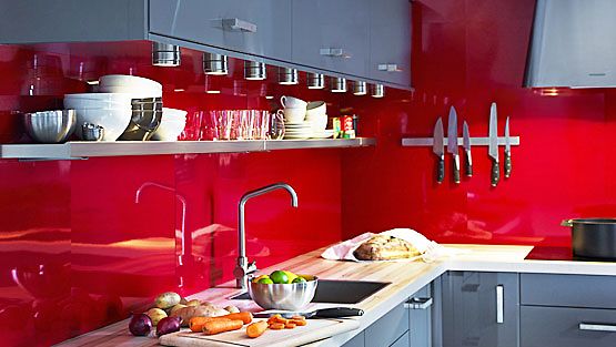 Ikean harmaat keittiönkaapit tasoittavat räiskyvää punaista. 