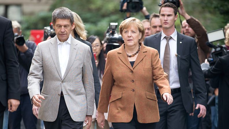 Liittokansleri Angela Merkel puolisonsa Joachim Sauerin kanssa äänestypaikalla Berliinissä 22.9.3013.