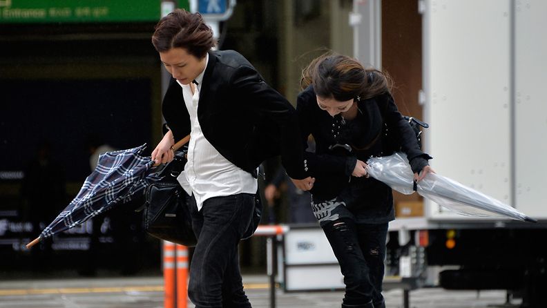 Jalankulkijat yrittivät taistella taifuuni Wiphan tuomia myrskytuulia vastaan Tokiossa 16. lokakuuta 2013.