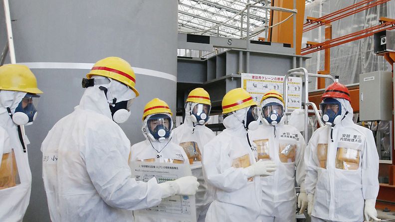 Japanese Prime Minister Shinzo Abe (R) is briefed about a facility of water treatment equipment called advanced liquid processing system (ALPS) by Fukushima Dai-ichi nuclear power plant chief Akiro Ono (3-R) during his inspection tour to the tsunami-crippled plant in Okuma, Fukushima Prefecture, northeastern Japan, 19 September 2013.