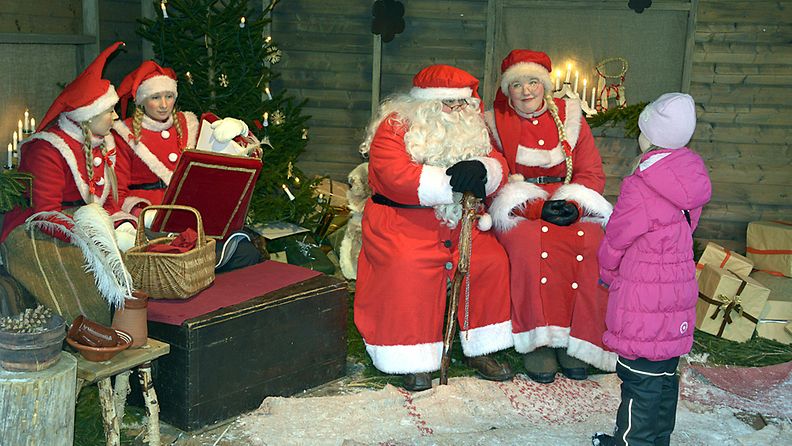 Joulupukki ja joulumuori jututtavat tyttöä Vanhan Suurtorin joulumarkkinoilla Turussa 8. joulukuuta 2012,