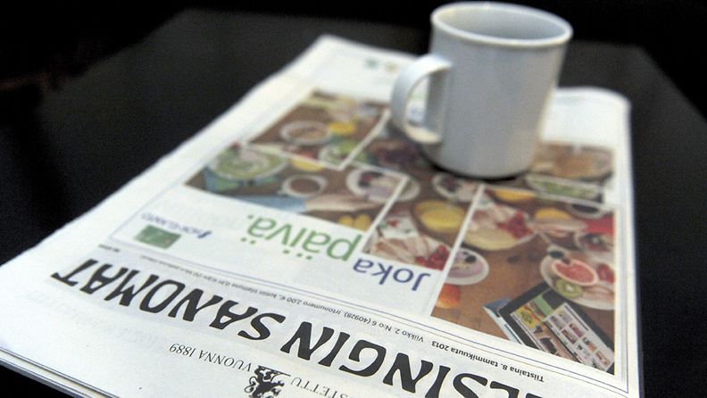 Tabloid-kokoinen Helsingin Sanomat aamukahvipöydässä Helsingissä 8. tammikuuta 2012. Maan suurin sanomalehti ilmestyy tästä päivästä lähtien uudessa, pienemmässä tabloidikoossa. 