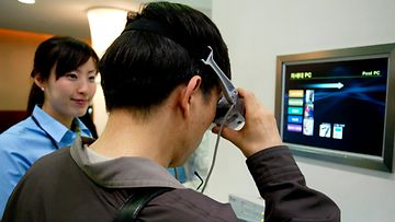 Eteläkorealainen mies kokeilee puettavaa tietokonetta messuilla Soulissa vuonna 2005