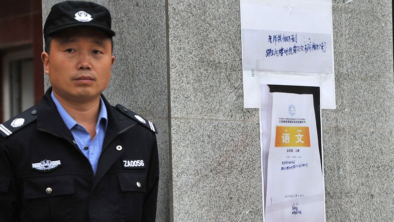 Vartija seisoo 10-vuotiaan pojan kopioidun viestin vieressä Chengdussa Kiinassa 31. lokakuuta 2013. 