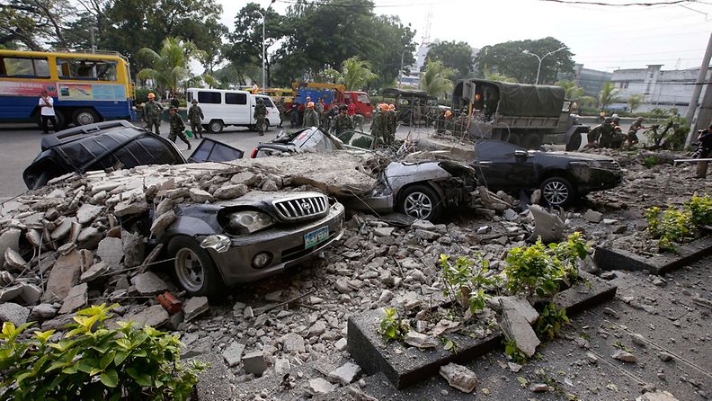 ipino soldiers clear the debris from damaged cars underneath rubble outside a building following a 7.2-magnitude earthquake in Cebu City, central Visayas, Philippines, 15 October 2013.