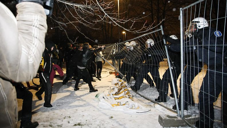 Kiakkovieraiden mielenosoittajat repivät mellakka-aitaa mellakkapoliisien edessä Tampereella 6. joulukuuta 2013. 