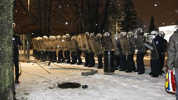Mellakkapoliisit odottavat kiakkovieraiden mielenosoittajia mellakka-aidan takana Tampere-talon edessä Tampereella 6. joulukuuta 2013