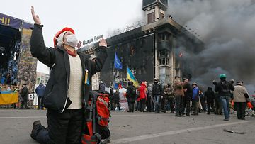 Nainen rukoili keskellä Kiovan mielenosoituksia 19. helmikuuta 2014.