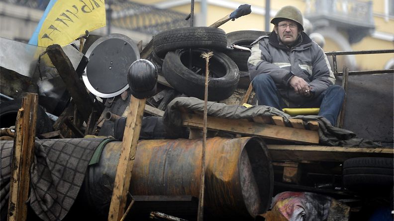Itsepuolustusjoukkoihin kuuluva mies istui barrikadilla Kiovan keskustassa.