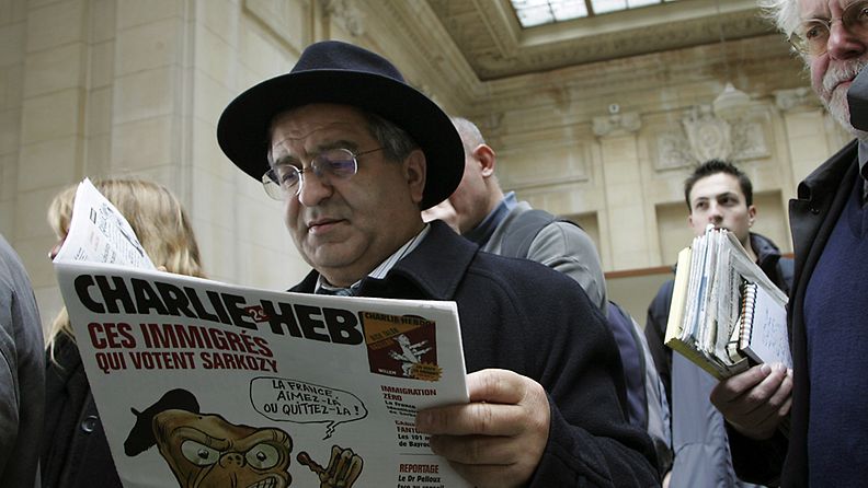 Didier Idjadi luki satiirilehteä odottaessaan oikeudenkäyntiä maaliskuussa 2007 Pariisissa.