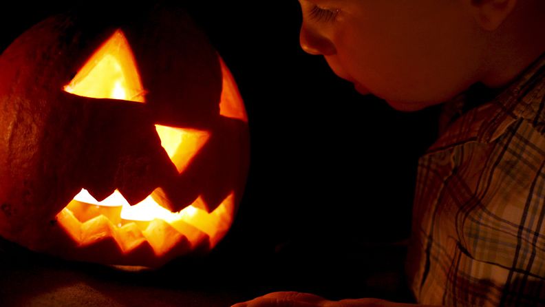 Pikkupoika tuijottaa Halloween-kurpitsaa Slovakian Pietanyssa.