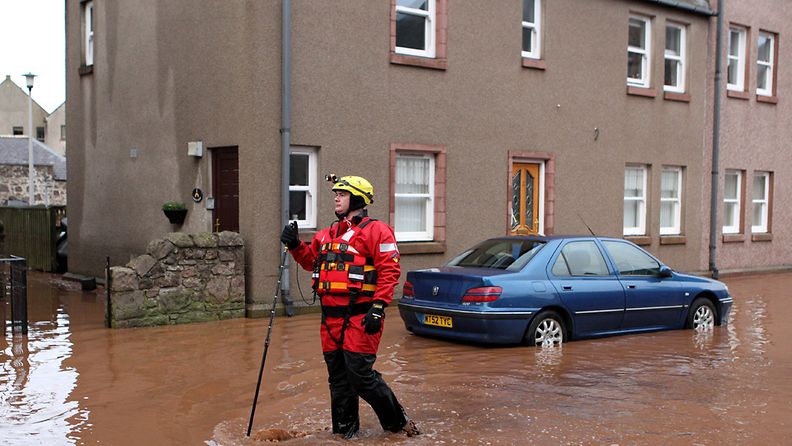 Palomies kahlasi tulvavesissä Skotlannin Aberdeenin lähistöllä sijaitsevassa Stonehavenissa 23. joulukuuta 2012.