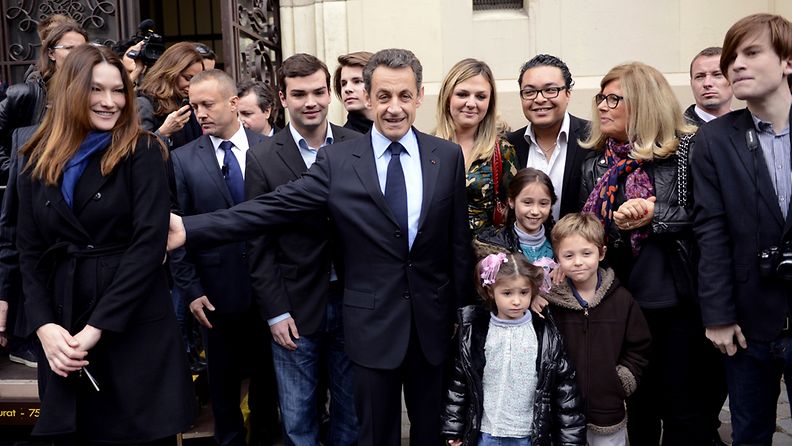 epa03192494 French incumbent President, and 'Union pour un Mouvement Populaire' (UMP) party candidate for the 2012 French Presidential election, Nicolas Sarkozy holds the arm of his wife Carla Bruni-Sarkozy as they leave a polling station in Paris, France, 22 Avril 2012. The second round of France's presidential elections will be held on 06 May 2012.