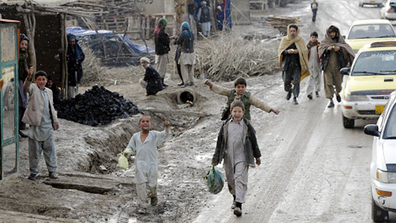 Afgaanilapsia kävelee päätien varrella Mazar-i Sharifissa Afganistanissa 30. tammikuuta 2013. Mm. suomalaisten ISAF-kriisinhallintajoukkojen tukikohta Camp Northern Lights sijaitsee Mazar-i Sharifissa. 