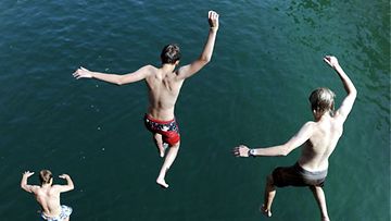 Nuoret miehet hyppäävät Limmat-jokeen Zürichissä Sveitsissä 10.7.2010. Lämpötila on kohonnut eri puolilla maata liki 35 asteeseen. (Kuva: EPA) 