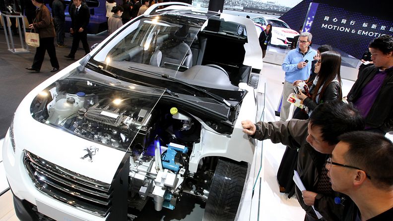 Chinese visitors look at a Peugeot Hybrid Air auto at the 15th Shanghai International Automobile Industry Exhibition at Shanghai New International Expo Center in Shanghai city, China, 20 April 2013. The auto expo will run from 21 to 29 April 2013 in Shanghai, and features some 1,300 autos including 111 cars that will have their premiere at the trade fair.