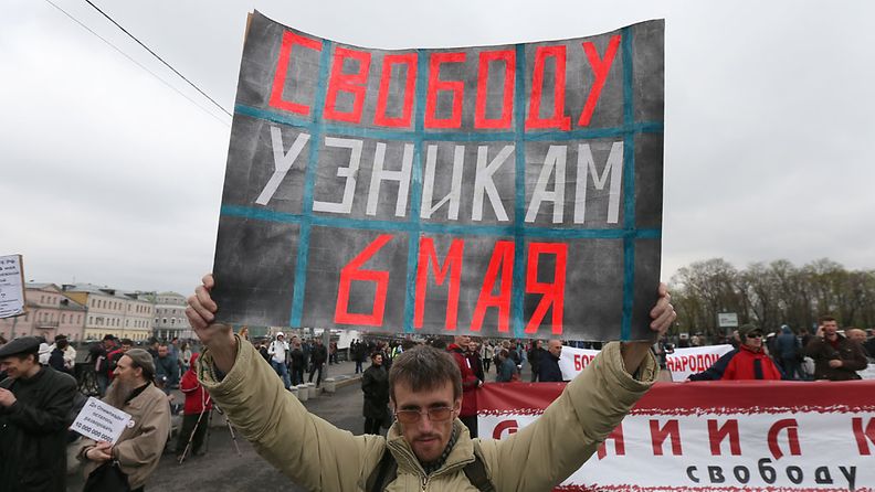 Opposition kannattaja Moskovassa. Julisteessa lukee: Vapaus vangeille. 