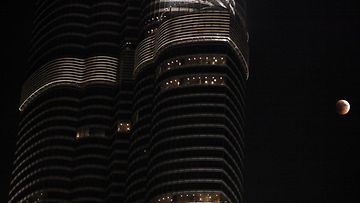Kuunpimennys Arabiemiraattien korkeimman rakennuksen vierestä kuvattuna.