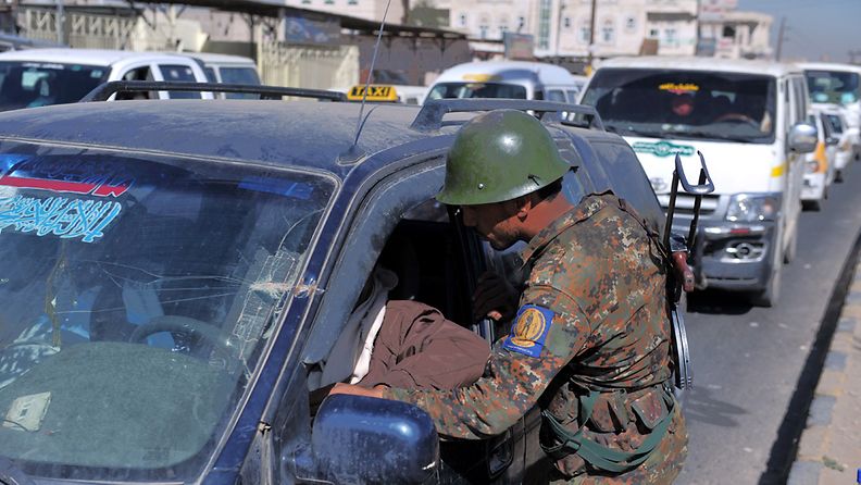 Turvallisuusjoukkojen edustaja tarkastaa autoa Jemenissä Sanaassa 22.joulukuuta 2012. Kaksi suomalaista ja yksi itävaltalainen siepattiin kaupungissa päivää aiemmin. 
