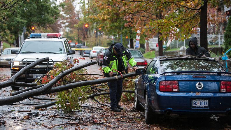 Poliisi auttaa siirtämään kaatunutta puuta Washington DC:n alueella.