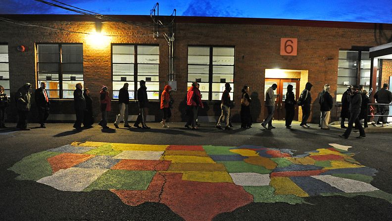 ALEXANDRIA, VA - NOVEMBER 06: People enter Washington Mill Elementary School to cast their vote in the U.S. presidential race, on November 6, 2012, in Alexandria, Virginia. Recent polls show that U.S. President Barack Obama and Republican presidential candidate Mitt Romney are in a tight race.