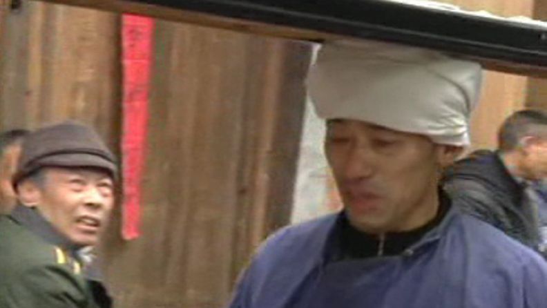 Yang Guangqiang hallitsee vanhan Dapen-taidon kantaa päänsä päällä pitkää ja painavaa tarjotinta. Kuvakaappaus AP:n videomateriaalista.