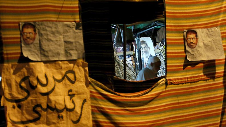 Posters of ousted president Mohamed Morsi are seen at tents of members of the Muslim brotherhood near Cairo University in Giza, Egypt, 29 July 2013. Egyptian authorities on 26 July ordered ousted president Mohammed Morsi to be detained for 15 days pending further investigations on charges of conspiring to carry out 'hostile acts' in the country, state-run newspaper al-Ahram online reported. Meanwhile, Morsi's backers and opponents were rallying for rival demonstrations across the country. 