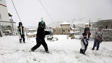 Lapset leikkivät lumessa Majdal Shamsin kylässä Israelissa Syyrian rajalla 9.1.2013 