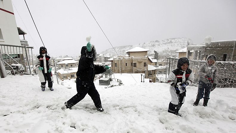 Lapset leikkivät lumessa Majdal Shamsin kylässä Israelissa Syyrian rajalla 9.1.2013 