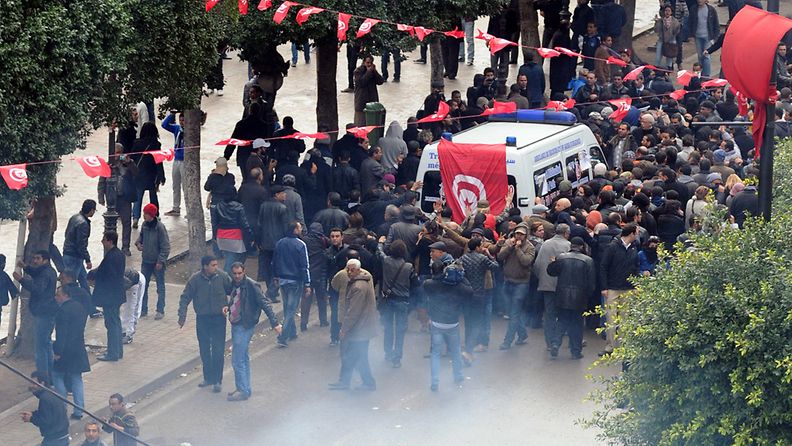 Mielenosoittajat piirittivät ambulanssin, joka kuljetti surmatun oppositiojohtan ruumista 6. helmikuuta 2013.