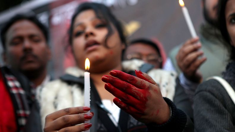 An Indian protester, with hands colored in fake blood, holds a candle during a protest campaign by Youth Congress against the gang rape of a student last week, in Calcutta, India, 28 December 2012. The 23-year-old Indian gang rape victim being treated in a Singapore hospital was in extremely critical condition and struggling to survive, doctors said on 28 December. The woman was raped and beaten in a moving bus in New Delhi on 16 December. The attack triggered protests in the Indian capital and other cities. 