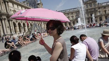Turistit viilensivät itseään Louvren taidemuseon suihkulähteessä Pariisissa 9.7.2010. Lämpötila on noussut Ranskan pääkaupungissa yli 30 asteeseen.