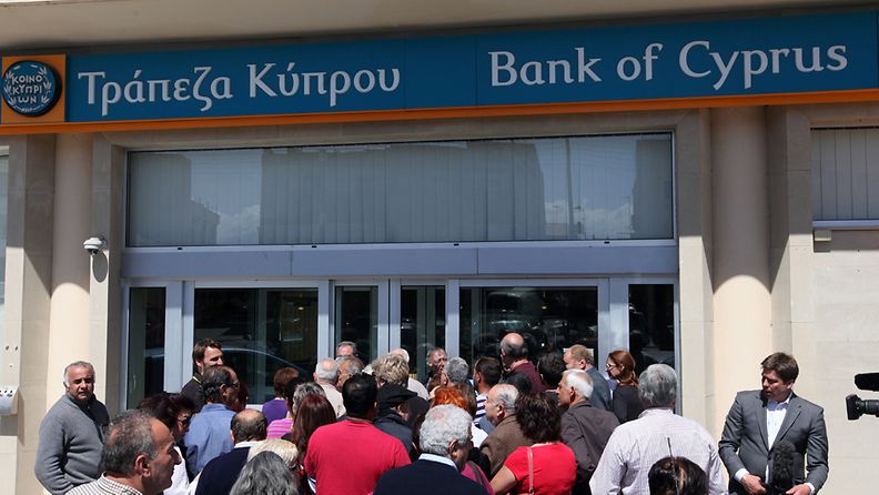 People wait in line in front of a branch of the Bank of Cyprus in Nicosia, Cyprus, 28 March 2013. All of the country's 26 banks were open from 12 pm until 6 pm (1000-1600 GMT) on 28 March with a withdrawal limit set at 300 euros (383 dollars) per person. Cyprus was braced for the reopening of its banks after nearly two weeks, after the government imposed tough capital controls for at least the next seven days. Police were going from bank to bank in central Nicosia to prevent problems, while dozens of people had started to queue in front of the banks' doors. 