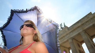 Nuori nainen suojautuu sateenvarjolla auringolta, joka nosti lämpötilan 37 asteeseen Berliinissä Saksassa 10.7.2010. (kuva: EPA)