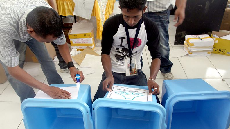 Vaalivirkailijat laittavat lappuja äänestyslaatikoihin Itä-Timorin Dilissä.