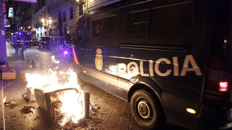 Poliisiauto palavan roska-astian vieressä säästöjä vastustavassa mielenosoituksessa Madridissa Espanjassa 19. heinäkuuta 2012.