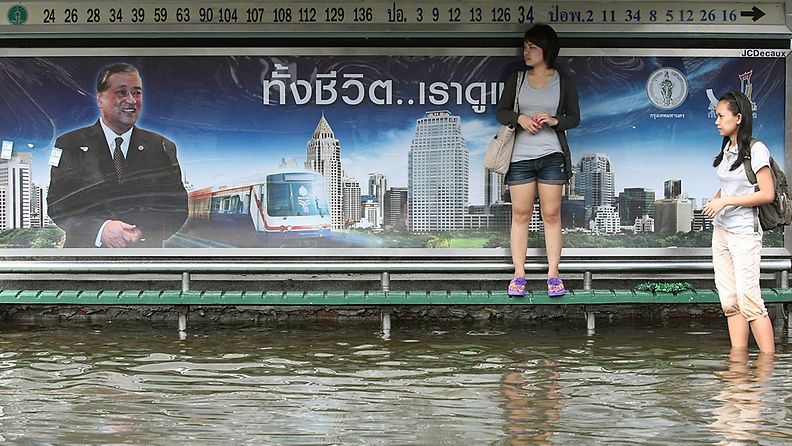 Naiset odottavat bussia Lat Phraossa bangkokin esikaupunkialueella 4.11.2011. 