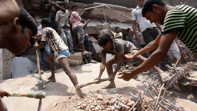 Siviilit auttavat pelastustöissä kerrostalon romahdettua Bangladeshissa 24.4.2013.