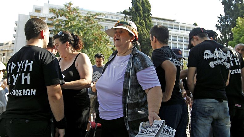 Vanhempi nainen odottaa äärioikeiston jakamaaa ruoka-apua Ateenan keskustassa.