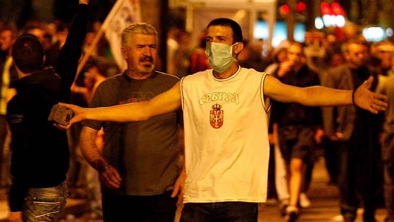 Mielenosoittaja uhkaa heittää kiven serbikenraali Ratko Mladicia tukevassa mielenosoituksessa Belgradissa 29.5.2011.