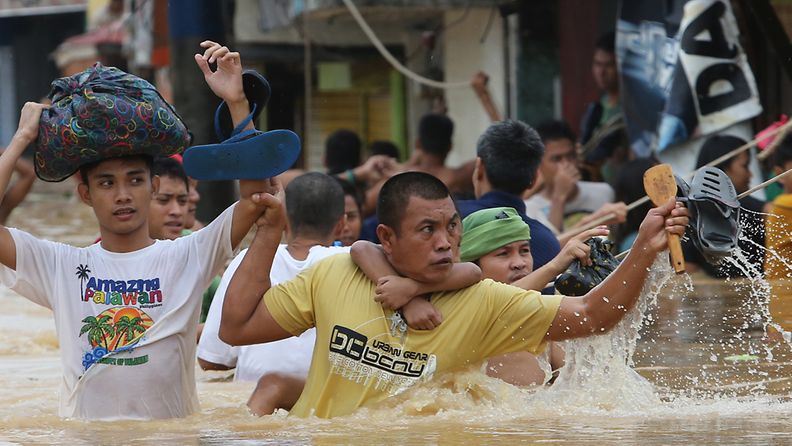 Asukkaat taistelevat tulvavesiä vastaan Marikinan kaupungissa Manilan itäpuolella 9. elokuuta.