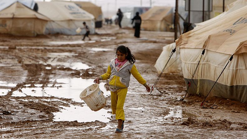 Tyttö kävelee syyrialaisten pakolaisleirillä Jordaniassa 9.1.2013. Aluetta ovat piiskanneet voimakkaat sateet, jotka ovat aiheuttaneet levottomuuksia leirillä.