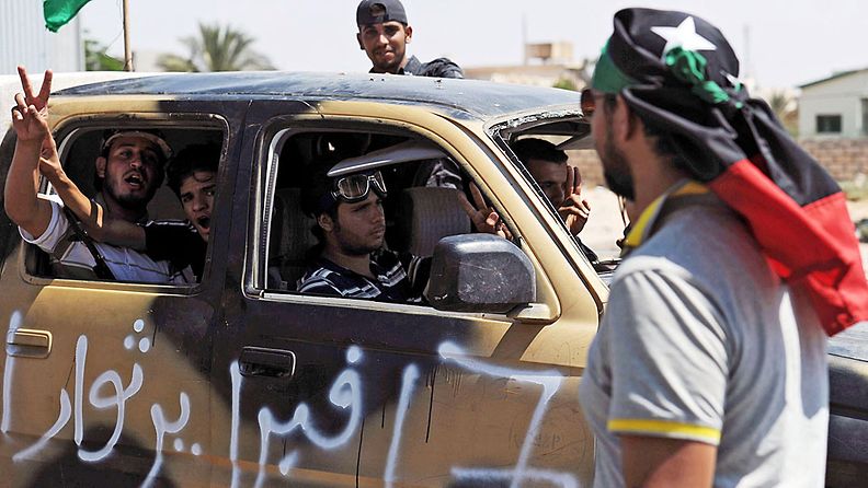 Kapinalliset tuulettavat voitonmrekein auton ikkunasta Tripolin tarkastuspisteella 24.8.2011.