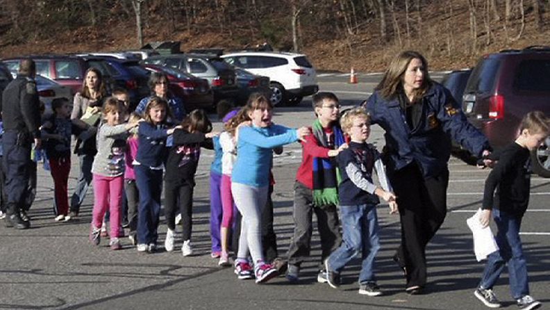 Järkyttyneistä lapsia evakuoidaan koulusta.